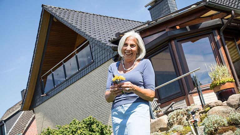 Eine Frau steht vor einem Einfamilienhaus.jpeg - Damit das eigene Zuhause im Alter nicht zur Last wird, muss man früh handeln. Eine Frau steht vor einem Einfamilienhaus.jpeg - Damit das eigene Zuhause im Alter nicht zur Last wird, muss man früh handeln.