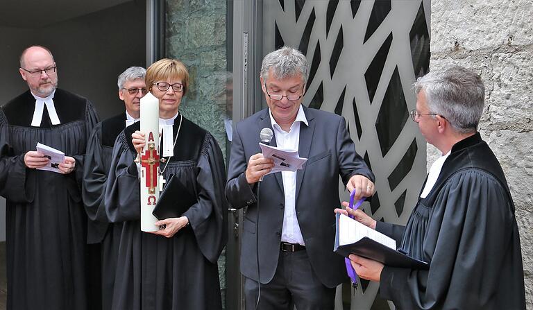 Architekt Karlheinz Keicher übergibt den Schlüssel an Pfarrer Wolfrum und diese reichte ihn weiter an die Küsterin Hermine Weber zum Aufschließen des Kirchenportals.