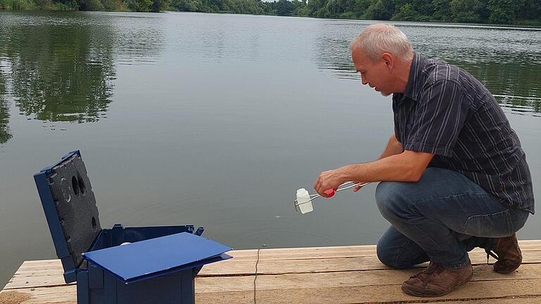 Der Hygieneinspektor des Landratsamtes Matthias Geib entnimmt am Seinsheimer Landschaftssee eine Wasserprobe.