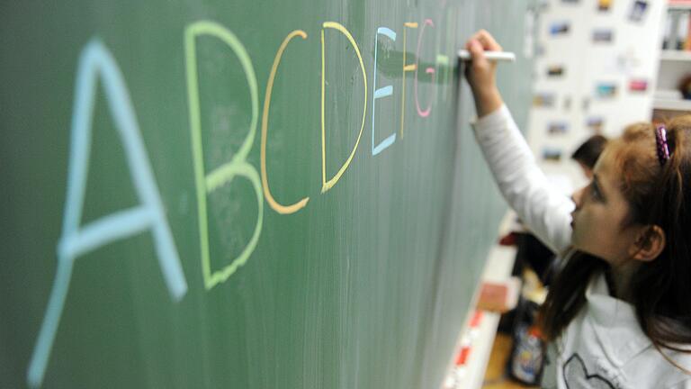 Eine Schülerin einer zweiten Klasse schreibt auf diesem Symbolbild in einer Schule das ABC an die Tafel. Bei den Haushaltsberatungen in Schweinfurt wurde beschlossen, dass die sehr erfolgreich arbeitenden pädagogischen Hilfskräfte ihre Arbeit auch weiterhin tun können. Eine Schülerin einer zweiten Klasse schreibt auf diesem Symbolbild in einer Schule das ABC an die Tafel. Bei den Haushaltsberatungen in Schweinfurt wurde beschlossen, dass die sehr erfolgreich arbeitenden pädagogischen Hilfskräfte ihre Arbeit auch weiterhin tun können.