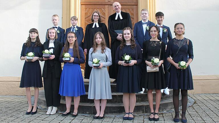 Bereits vor dem Festgottesdienst stellten sich die Jugendlichen zu einem Erinnerungsbild am Seitenportal der Kirche auf. Von links (hintere Reihe): Julian Andritschke, Julian Dellert,  Pfarrerin Martina Posekardt, Pfarrer Martin Popp-Posekardt, Tristan Holzheid und Valentin Freß; vordere Reihe: Lena Fassl, Greta Posekardt, Elisa Vollert, Anna-Lena Vollert, Nele Flachsenberger, Jamie-Juliana Unogu und Vivienne Iherigbo.