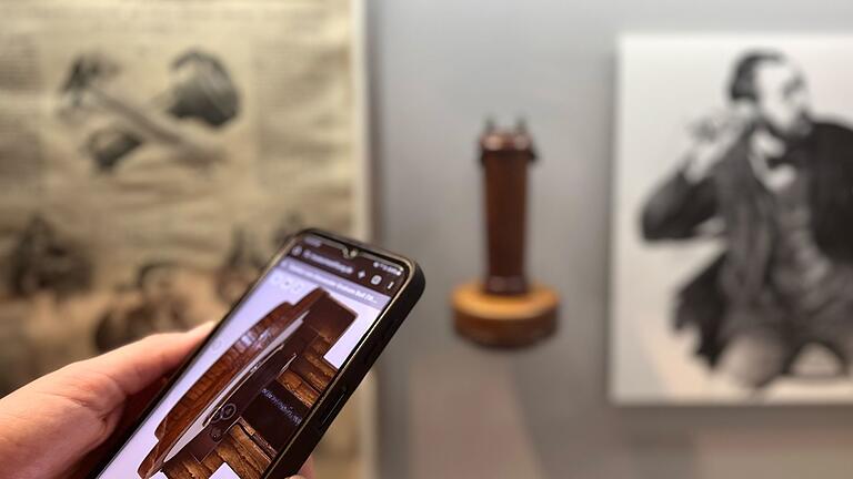 Auf einem Smartphone ist ein 3D-Exponat zu sehen.       -  Historisches Telefon hoch zwei: Einmal direkt in der Ausstellung und einmal als 3D-Exponat auf dem Smartphone.