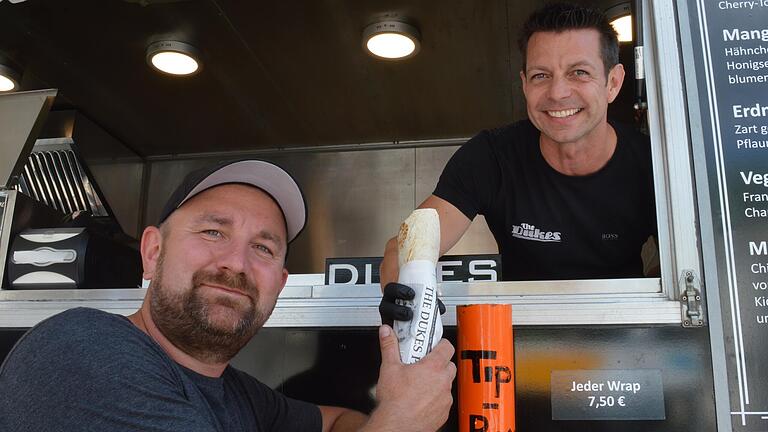 Foodtruck-Festival Bad Kissingen : Veranstaltungsleiter Robert Steinbach lässt sich von 'Duke' Steffen Kreß einen Wrap über die Theke reichen. Foodtruck-Festival Bad Kissingen : Veranstaltungsleiter Robert Steinbach lässt sich von 'Duke' Steffen Kreß einen Wrap über die Theke reichen.