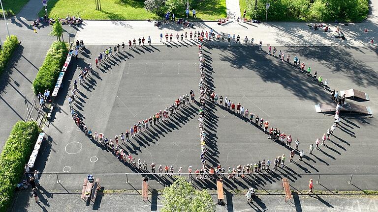 Das Friedenszeichen 'Peace' formten die Schülerinnen und Schüler vor dem Start des Spendenlaufs.