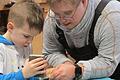 Ein schönes Beispiel für gelebte Inklusion und Teamarbeit: Ein Vorschulkind und ein Mitarbeiter mit Behinderung arbeiten konzentriert und mit viel Sorgfalt an der Anfertigung des Spielzeugs.