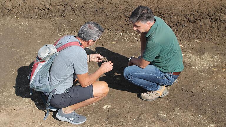 An insgesamt 35 Stellen zeichneten sich in der Erde dunkle Stellen ab, die von Vertiefungen herrühren, die die Menschen in der Bronzezeit als Vorratsgruben nutzten. Museumsleiter Bertram Schulz (links) und Architekt Martin Giedl&nbsp; begutachten die Reste von Vorratsgefäßen, die bis heute in den Gruben liegen.