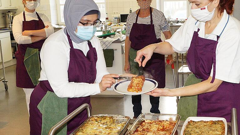 Nach dem Kochen wird verkostet: Olga Ruppel (rechts) reicht Cemile Özogul Cannelloni. Die sind nicht mit Fleisch, sondern mit Linsentatar gefüllt und kommen bei den Teilnehmerinnen bestens an.