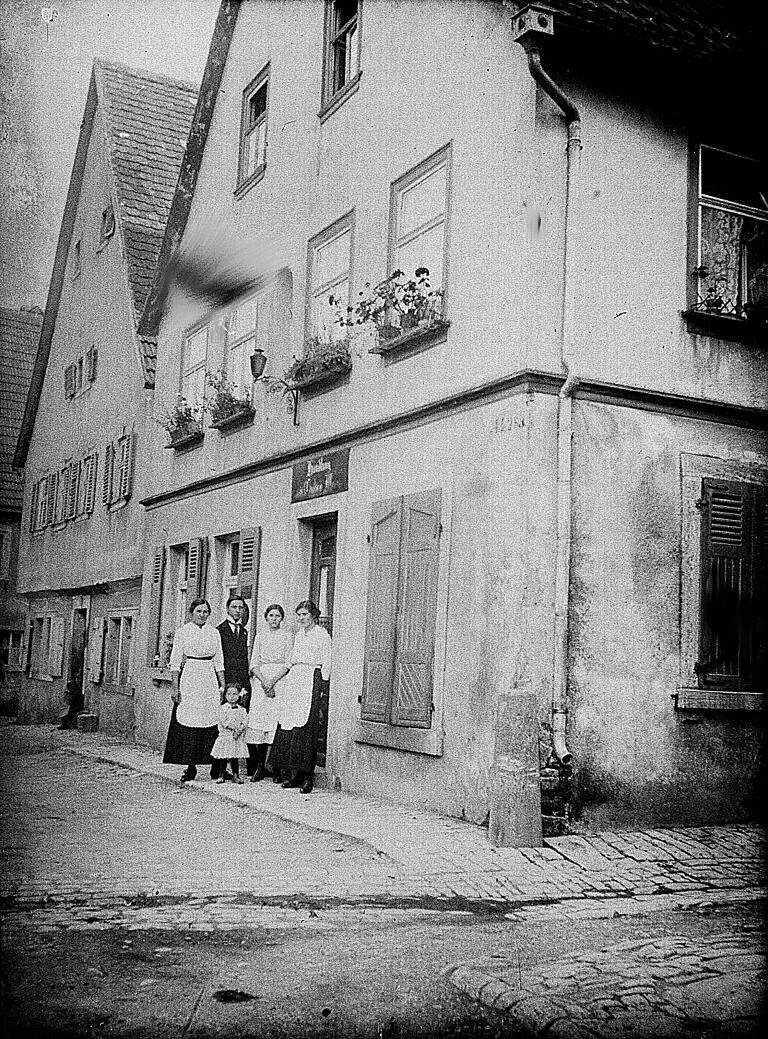 Diese Aufnahme zeigt den Laden am Schafbach in Goßmannsdorf mit der Belegschaft, vermutlich Verwandte des Fotografen. Diese Aufnahme zeigt den Laden am Schafbach in Goßmannsdorf mit der Belegschaft, vermutlich Verwandte des Fotografen.