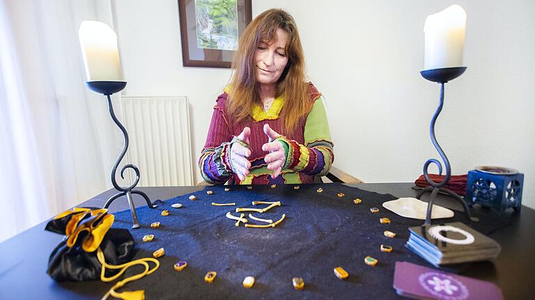 Runenhex Helga Angerer während ihrem Runenwurf mit Knochen. Runenhex Helga Angerer während ihrem Runenwurf mit Knochen.