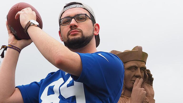 Beobachtet vom Brückenheiligen Nepomuk, ist Christopher Meindl aus dem unterfränkischen Thulba in die Rolle des Quarterbacks geschlüpft. Foto: Jürgen Schmitt       -  Beobachtet vom Brückenheiligen Nepomuk, ist Christopher Meindl aus dem unterfränkischen Thulba in die Rolle des Quarterbacks geschlüpft. Foto: Jürgen Schmitt