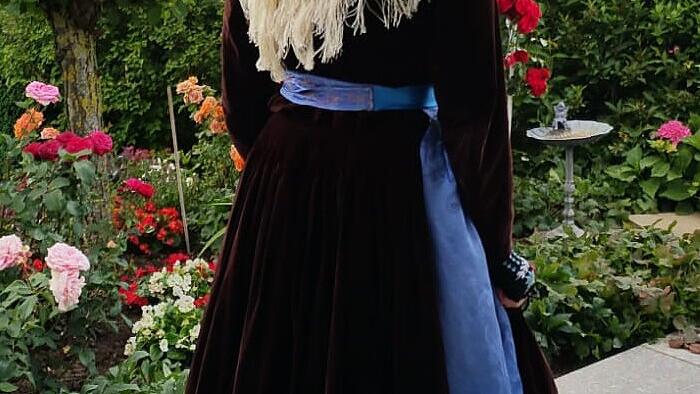 Das Samtblusenkleid ersetzte die Festtracht mit dem Körres. Hier wurde das eigentliche Winter-Kopftuch („Hinterbindhulla“) als Schultertuch wie bei der alten Tracht getragen. Auffällig ist auch die uni-farbene Seidenschürze mit eingewebtem Blumenmuster. Das Samtblusenkleid ersetzte die Festtracht mit dem Körres. Hier wurde das eigentliche Winter-Kopftuch („Hinterbindhulla“) als Schultertuch wie bei der alten Tracht getragen. Auffällig ist auch die uni-farbene Seidenschürze mit eingewebtem Blumenmuster.