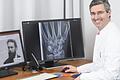 Links im Bild ist das erste Röntgenbild zu sehen, eine Aufnahme der Hand von Wilhelm Conrad Röntgens Ehefrau Anna Bertha. Auf dem rechten Computerbildschirm sieht man die Aufnahme der Hand eines heutigen Patienten am Universitätsklinikum Würzburg. Die Qualität der Röntgenbilder hat sich in 100 Jahren extrem verbessert.
