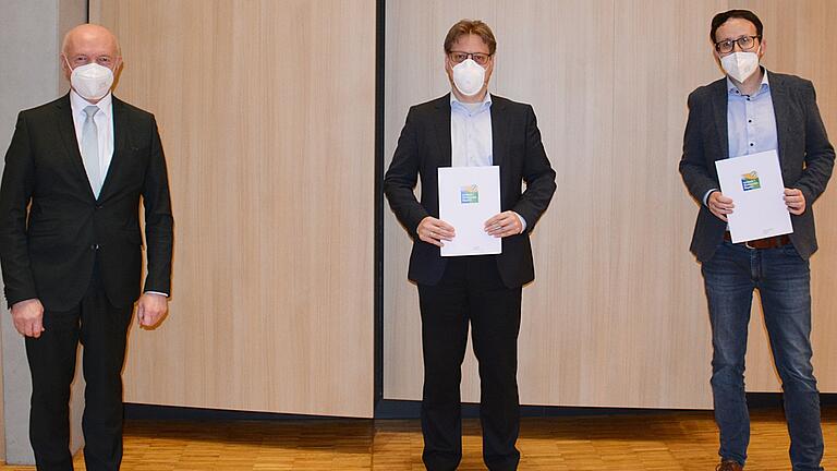 Landrat Thomas Habermann zeichnete Martin Büchs, Geschäftsführer  der Jopp Holding GmbH in Bad Neustadt, sowie Bastian Steinbach, Geschäftsführer der Adolf Steinbach Steinindustrie-Schotterwerke in Salz (von links) mit der Klimapakt-Urkunde aus.