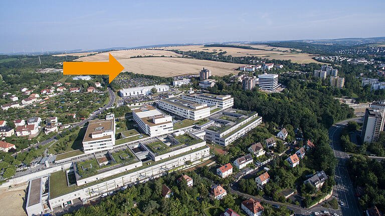Das Schrägluftbild zeigt die Lage des Erweiterungsgeländes (Pfeil) oberhalb des Uniklinik-Parkplatzes. Im Vordergrund ist das Doppelzentrum für Operative und Innere Medizin mit seinen vier Bettenhäusern zu erkennen. Das Schrägluftbild zeigt die Lage des Erweiterungsgeländes (Pfeil) oberhalb des Uniklinik-Parkplatzes. Im Vordergrund ist das Doppelzentrum für Operative und Innere Medizin mit seinen vier Bettenhäusern zu erkennen.