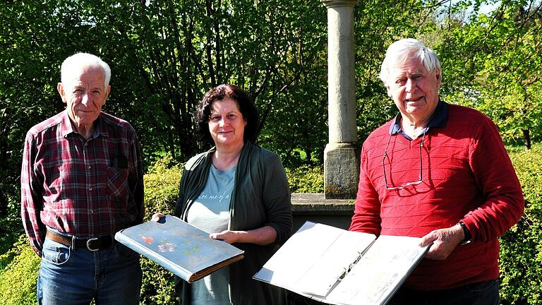 Übergabe der Sammlung von historischen Ansichskarten, die im alten Pfarrhaus von Kolitzheim entdeckt wurden. Der langjährige Seelsorger von Kolitzheim, Pfarrer Ludwig Öhrlein hatte sie in der Mappe gesammelt, die Archivarin Andrea Karbacher hält die Sammelmappe in der Hand, in der der Priester die Ansichtskarten eingeordnet hatte. Kreisheimatpfleger Hilmar Spiegel hält die aktuelle Sammlung. Arnold Heß, der das Archiv der Pfarrei St. Jakobus in Herlheim betreut, freut sich mit.