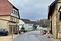 Die Kreisstraße verläuft hier zwischen Privatgebäuden, sodass die Randflächen nicht begehbar sind. Nun will man sich bemühen, hier wenigstens einen schmalen Gehweg durchzuführen.