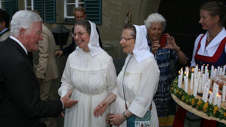 Glückwünsche: Zwei Ordensschwestern gratulieren Albrecht Fürst zu Castell-Castell zu seinem 90. Geburtstag nach dem Dankgottesdienst in Castell. Rechts sieht man schon die Torte mit 90 Kerzen für den Jubilar aus dem Hotel Leicht, die Andrea und Georg-Friedrich Leicht überreichten.