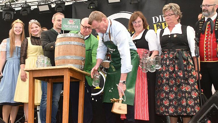 Schwupps, da wäre der Bieranstich beinahe zur Bierdusche geworden. Doch Bürgermeister Peter Juks blieb Herr der Lage. Mit im Bild von links: Weinprinzessin Ronja Grünewald, Zuckerfee Magdalena Gebhardt, Braumeister Christoph Kretz, Brauerei-Chef Dietrich Oechsner, Bezirksrätin Rosa Behon und die Vorsitzenden des Volkstrachtenvereins, Rosi Brauner und Andreas Mohr.