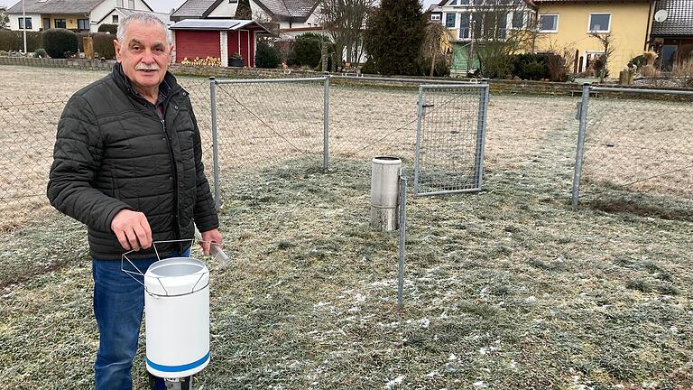Wetterbeobachter Hilmar Mauer steht am automatischen Regenmesser der Klimastation in Merkershausen.