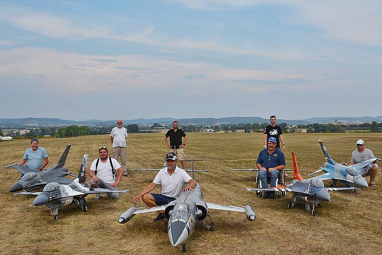 Gruppenbild der internationalen Modellfliegergruppe mit im Hintergrund Alfred Hoffmann, Vorsitzender des Aero Club Bad Königshofen und Markus Ammon, der die Kontakte hergestellt hat.