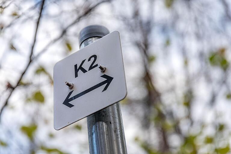 Der Weg ist als 'K2' mit schwarzer Schrift auf weißem Grund ausgeschildert. Der Weg ist als 'K2' mit schwarzer Schrift auf weißem Grund ausgeschildert.