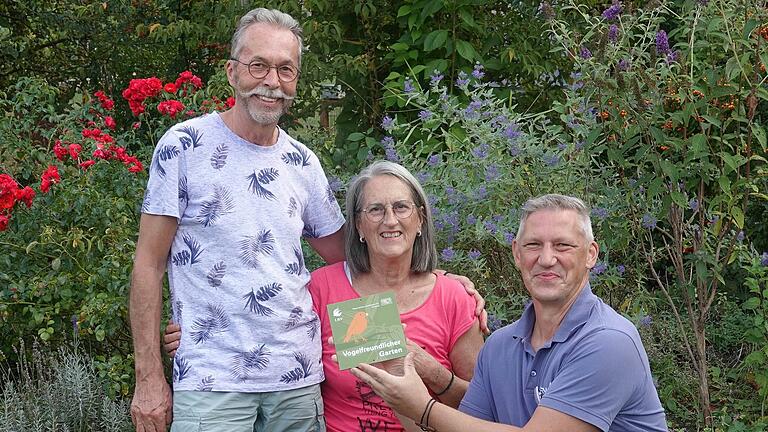 Ronny Zezula (rechts) von der LBV-Gartenjury bei der Übergabe der Auszeichnung für den vogelfreundlichen Garten an Janet und Markus Baumann.