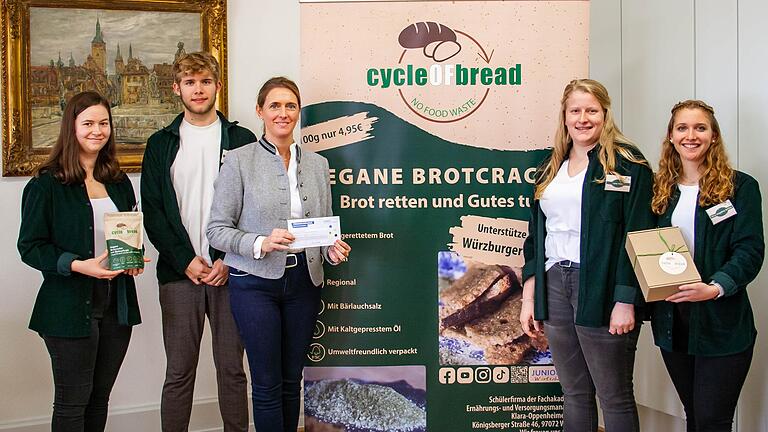 Dritte Bürgermeisterin Judith Jörg (Mitte) inmitten der Vertreterinnen und Vertreter der Schülerfirma 'cycle of bread' der Klara-Oppenheimer-Schule. Das Unternehmen produziert und vermarktet vegane Cracker aus gerettetem Brot. Dritte Bürgermeisterin Judith Jörg (Mitte) inmitten der Vertreterinnen und Vertreter der Schülerfirma 'cycle of bread' der Klara-Oppenheimer-Schule. Das Unternehmen produziert und vermarktet vegane Cracker aus gerettetem Brot.