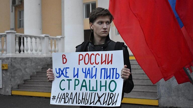 Alexej Schwarz bei einer Protest-Kundgebung in Russland. Auf seinem Plakat steht: 'Schon das Tee Trinken ist in Russland gefährlich. Nawalny, lebe!'