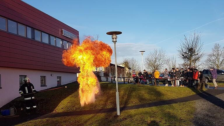 Schüler der Karl-Ludwig-von-Guttenberg Grundschule beim Thema Fettbrand mit dem erfahrenen Brandmeister der Feuerwehr, Stephan Biedermann.