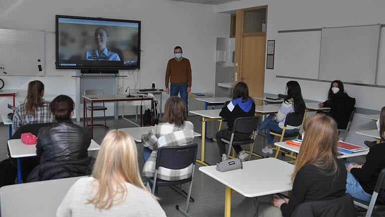 Schülerinnen und Schüler der Oberstufe des Matthias-Grünewald-Gymnasiums in der Videokonferenz mit Bundeswehr-Jugendoffizier Amelie Nägele und Gemeinschaftskundelehrer Dietrich Röbbelen.