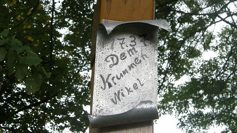 Die Tafel erinnert an die Hinrichtung von Nikolaus Luther 1737, errichtet in der Allee an der Theinfelder Straße.  Foto: Philipp Bauernschubert       -  Die Tafel erinnert an die Hinrichtung von Nikolaus Luther 1737, errichtet in der Allee an der Theinfelder Straße.  Foto: Philipp Bauernschubert