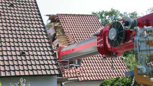 Kran stürzt auf Wohnhaus       -  Als er einen Baukran in Bibergau von der Straße auf ein Wohngrundstück heben sollte, ist am Freitagvormittag ein 60-Tonnen-Autokran umgekippt und auf das Wohnhaus gestürzt.