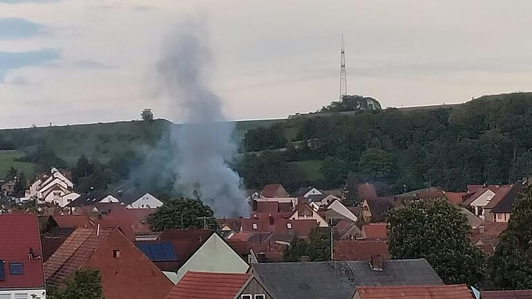 Brand in Theilheim: Eine Rauchsäule steht über den Dächern.