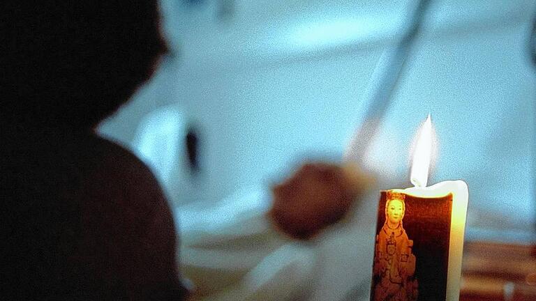 Hospiz-Bewegung ermöglicht würdevollen Tod       -  Eine Kerze steht am Sterbebett eines Bewohners im Hospiz 'St. Hildegard' in Bochum (Archivfoto von 1998). Entstanden ist die Hospizbewegung in den 60er Jahren in England und in den USA. Ziel ist es, möglichst allen Menschen einen Schmerz- und angstfreien, würdevollen Tod in familiärer Umgebung zu ermöglichen. In Deutschland gibt es inzwischen fast 600 ambulante Hospizdienste und rund 80 stationäre Einrichtungen - doppelt soviele wie noch vor fünf Jahren. (Siehe epd-Bericht vom 13.10.2000!) DER ABDRUCK DES EPD-FOTOS IST HONORARPFLICHTIG!