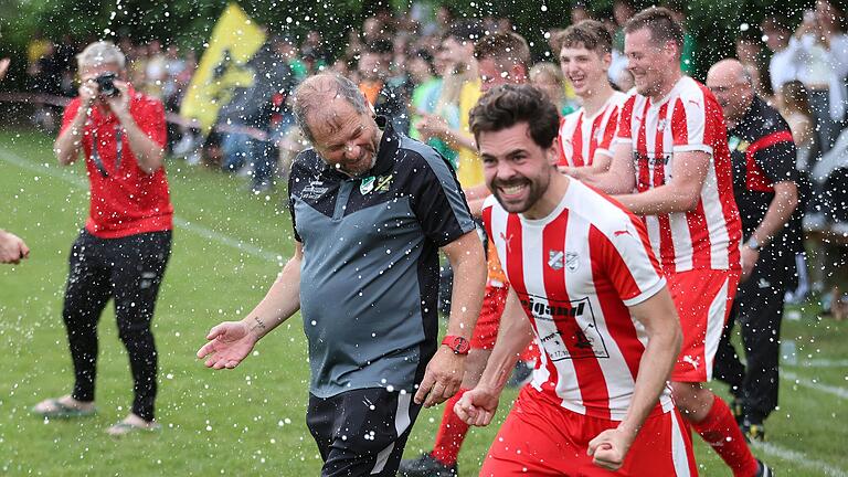 Mit dem Schlusspfiff knallen die Korken: Die SG Üchtelhausen-Zell um Trainer Frank Bonfig (links) und Kapitän Aron Hatwieger schafft gegen Kleinsteinach die Rückkehr in die Kreisliga.