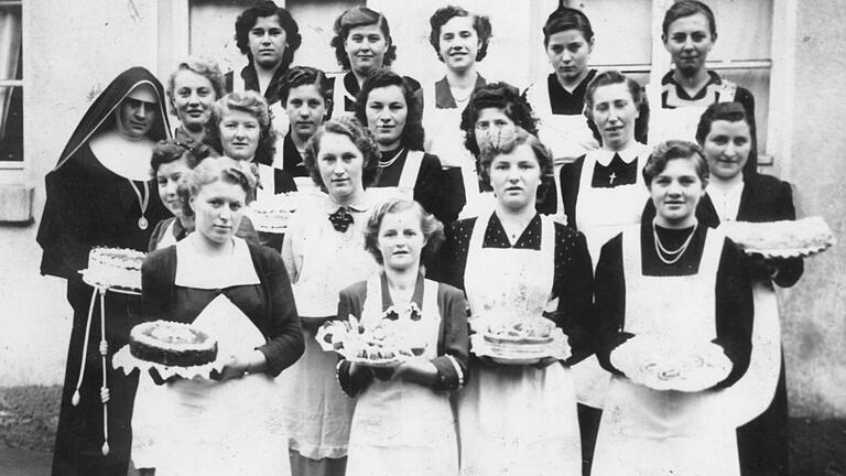Stolz präsentieren die Teilnehmerinnen des 1952 in der damaligen 'Kinderbewahranstalt' abgehaltenen Koch- und Backkurses ihre Torten. Mit im Bild die Kursleiterin, eine Ordensschwester des Klosters Oberzell bei Würzburg. Stolz präsentieren die Teilnehmerinnen des 1952 in der damaligen 'Kinderbewahranstalt' abgehaltenen Koch- und Backkurses ihre Torten. Mit im Bild die Kursleiterin, eine Ordensschwester des Klosters Oberzell bei Würzburg. 