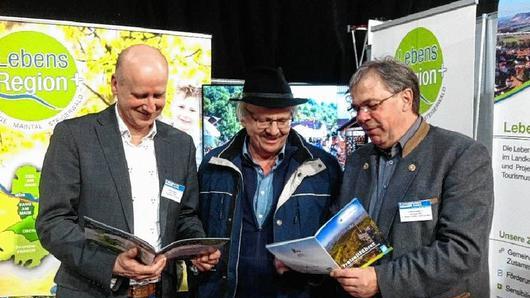 Auf der Immobilienmesse Franken in Bamberg warben die Bürgermeister der &bdquo;Lebensregion +&ldquo; mit der Schönheit ihrer Gemeinden. Das Bild zeigt Knetzgaus Bürgermeister Stefan Paulus, der den Messeauftritt auch organisierte, und Sands Bürgermeister Bernhard Ruß im Gespräch mit einem Messebesucher.