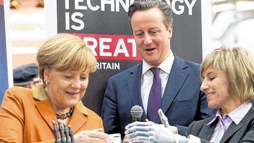 Eine künstliche Hand: Bundeskanzlerin Angela Merkel und der britische Premierminister David Cameron lassen sich auf der Cebit von der Fallschirmspringerin Claudia Breidbach ihre Handprothese vorführen, die von einer britischen Firma entwickelt wurde.