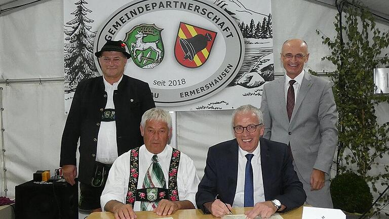 Die Bürgermeister (vorne von links) Michael Gansler und Günter Pfeiffer unterzeichneten im Beisein der Landräte (stehend von links) Anton Speer und Wilhelm Schneider die offizielle Urkunde zur Gemeindepartnerschaft zwischen Ermershausen und Unterammergau.