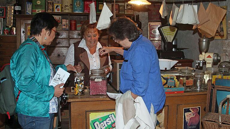 Lore Göbel, die 'Mutter der Kirchenburg' in Aschfeld zeigt Besucherinnen die Einrichtung eines alten Krämerladens. Lore Göbel, die 'Mutter der Kirchenburg' in Aschfeld zeigt Besucherinnen die Einrichtung eines alten Krämerladens.