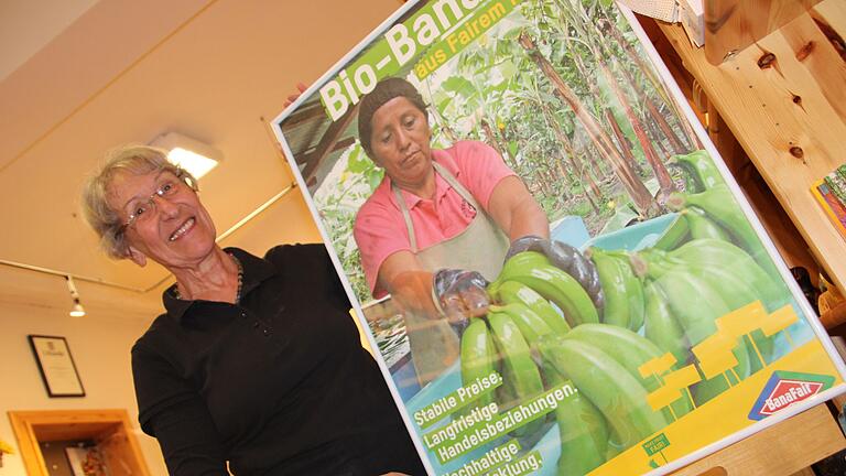Info für die Besucher: Christa Heinrich hält im Kitzinger Weltladen ein Plakat von BanaFair in die Höhe Info für die Besucher: Christa Heinrich hält im Kitzinger Weltladen ein Plakat von BanaFair in die Höhe