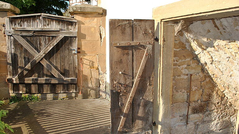 Unter Denkmalschutz: Der gesamte Gutshof steht unter Denkmalschutz, hier sieht man die Hofmauer mit kleinem Tor und den Abgang zum Keller. Unter Denkmalschutz: Der gesamte Gutshof steht unter Denkmalschutz, hier sieht man die Hofmauer mit kleinem Tor und den Abgang zum Keller.