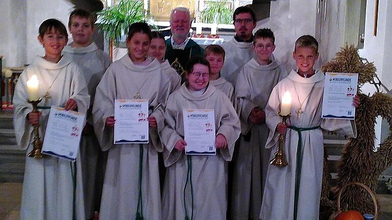 In der vorderen Reihe (von links) sind die vier neuen Ministrantinnen und Ministranten zu sehen: Kilian Walter, Leni Gerber, Abby Scholl und Leopold Sauer. Sie wurden im Erntedank Gottesdienst feierlich von Pater Matthäus Klein in der Kirche St. Lambertus in Opferbaum eingeführt.