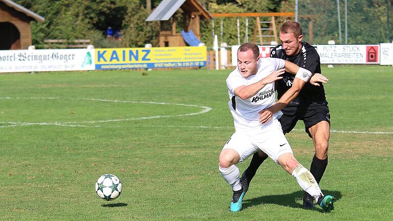 Sands Kapitän André Karmann (rechts, hier im Zweikampf mit dem Karlburger Josef Burghard) erlebte nach seiner Verletzung von der Bank aus ein unglaubliches Spiel.