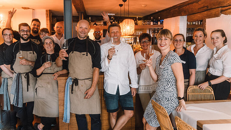 Eröffnungsfreude im Weinforum Franken: Chefkoch Rainer Trautenbach und die Inhaber Jochen Würtheim und Carina Valtin (Mitte vorne v. li) stoßen an mit (v. l.): Manuel Armbruster, Matthias Schlereth, Mameko Mazloum, Selina Krimm, Anne Röhrig, Anselm Moersch, Bartender Tobias Reulein, Bianca Scherpf, Silke Lange, Lara Seifert und Sommeliere Kyra Adler.