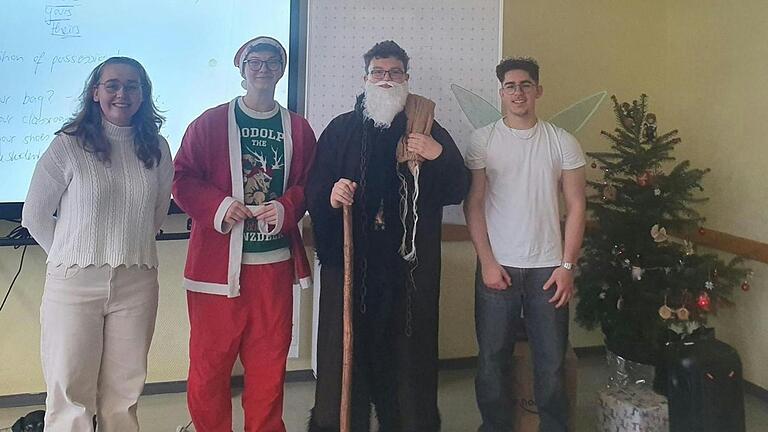 Mája Kestler als Weihnachtsengel, Joschua Rippel als Nikolaus, Felix Müller als Knecht Ruprecht und Arian Munir als Weihnachtsfee in Aktion in einem Klassenzimmer.