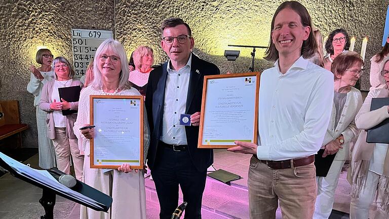 Bürgermeister Armin Warmuth sorgte für eine Riesenüberraschung am Ende des Guig-Jubiläumskonzerts. Er überreichte die „Stadtplakette für kulturelle Verdienste“ an Maria Heckmann (links) für die Gesangs- und Instrumentalgruppe Guig und an Dirigent ... - Bürgermeister Armin Warmuth sorgte für eine Riesenüberraschung am Ende des Guig-Jubiläumskonzerts. Er überreichte die „Stadtplakette für kulturelle Verdienste“ an Maria Heckmann (links) für die Gesangs- und Instrumentalgruppe Guig und an Dirigent Stefan Ammersbach (rechts). Bürgermeister Armin Warmuth sorgte für eine Riesenüberraschung am Ende des Guig-Jubiläumskonzerts. Er überreichte die „Stadtplakette für kulturelle Verdienste“ an Maria Heckmann (links) für die Gesangs- und Instrumentalgruppe Guig und an Dirigent ... - Bürgermeister Armin Warmuth sorgte für eine Riesenüberraschung am Ende des Guig-Jubiläumskonzerts. Er überreichte die „Stadtplakette für kulturelle Verdienste“ an Maria Heckmann (links) für die Gesangs- und Instrumentalgruppe Guig und an Dirigent Stefan Ammersbach (rechts).