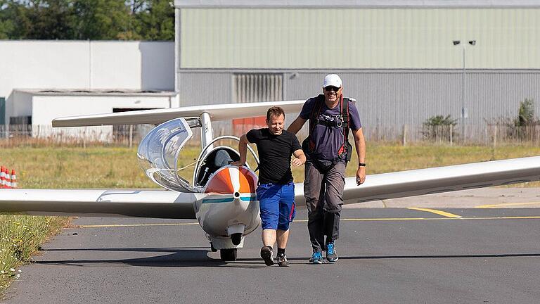 Die Flugschüler Markus Neubert (links) und Lothar Pfeiler ziehen das Flugzeug auf die Landebahn.
