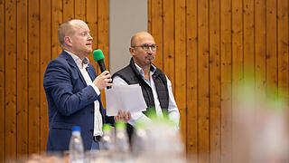 Rund 300 Menschen besuchen am 07.04.25 die Informationsveranstaltung in der Mehrzweckhalle in Himmelstadt zur geplanten und umstrittenen Unterkunft für Geflüchtete. Zum Diskussionsabend wurden auch Vertreter der Politik, der Regierung und der Polizei geladen. Im Bild von links: Benjamin Kraus, Sachgebietsleiter &quot;Flüchtlingsbetreuung und Integration&quot; bei der Regierung von Unterfranken. Auch sein Kollege Lothar Menzel, zuständig für die Gemeinschaftsunterkünfte, ist vor Ort.