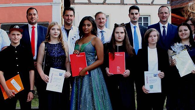 Die Schul- und Fächerbesten mit Abschluss der &bdquo;Mittleren Reife&ldquo;; vordere Reihe von links Jonas Pflaum, Daniel Schraub, Christina Basel, Felicia Flores, Emilia Klein, Shakira Pohl und Viola Stöcklein mit den Sponsoren der Geldpreise und Rektor Raimund Willert (rechts).